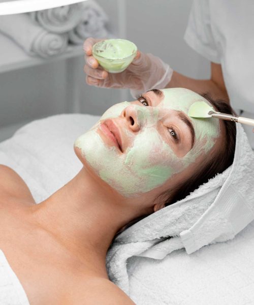 beautician-applying-face-mask-female-client